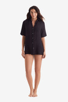 Woman wearing a black short sleeve button up shirt