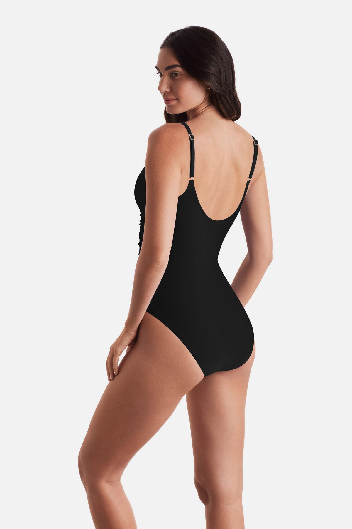 Woman wearing a black one-piece swimsuit with frills on the edges